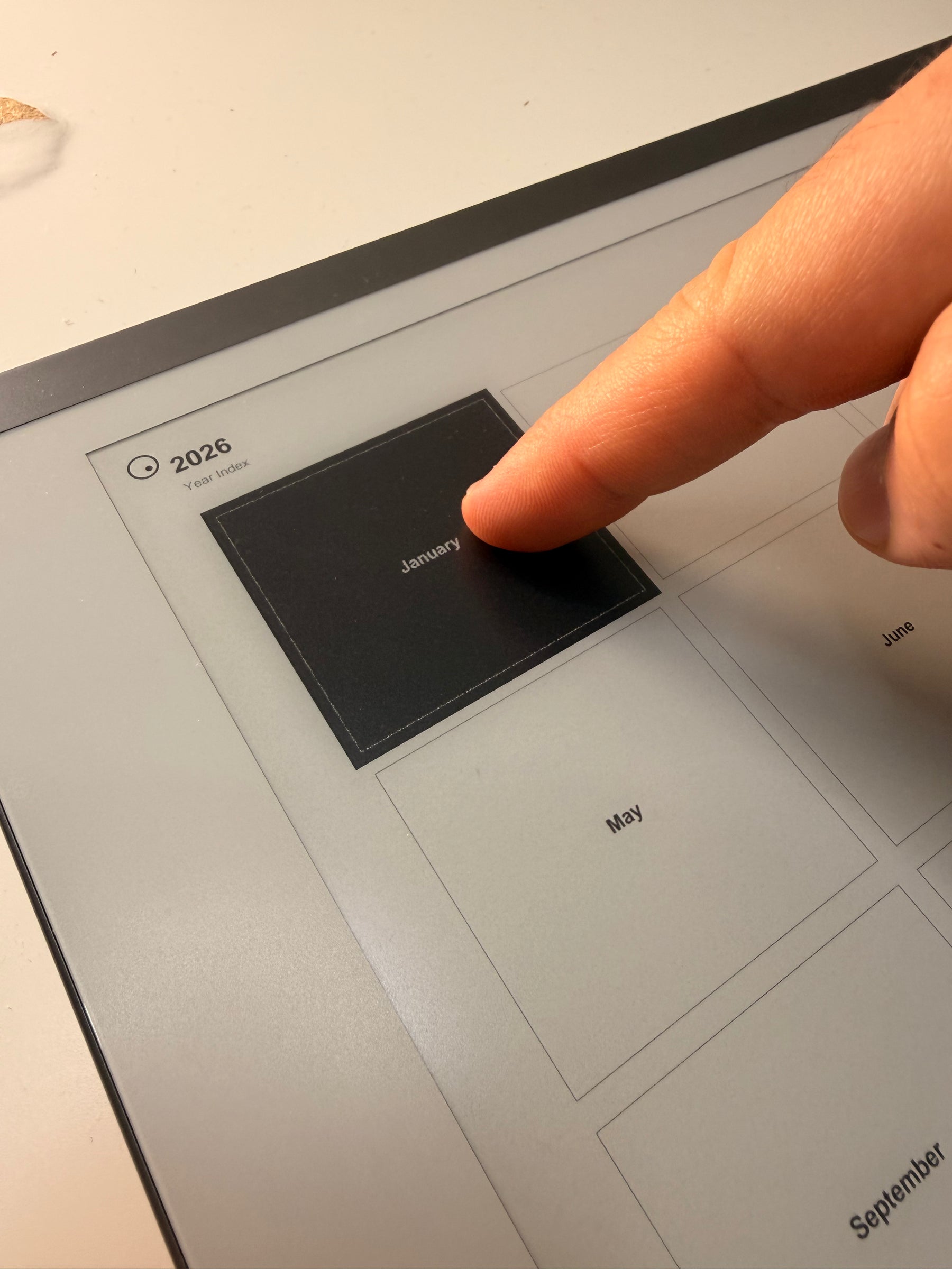 A finger selects January on the year index.